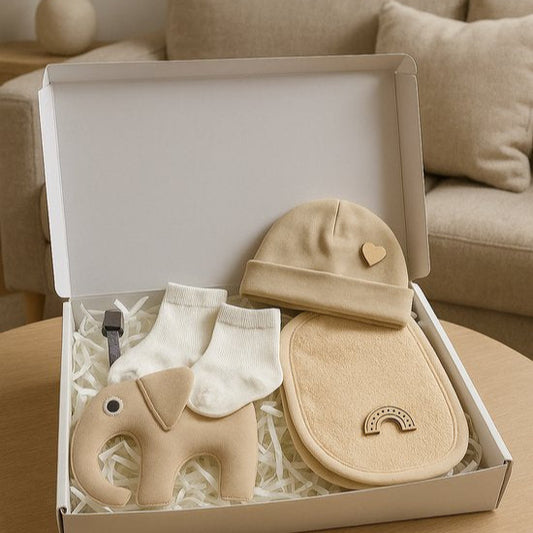 Beige kraamcadeau baby giftset met babymutsje, slab met regenboog, witte sokjes en olifant knuffel in geschenkdoos